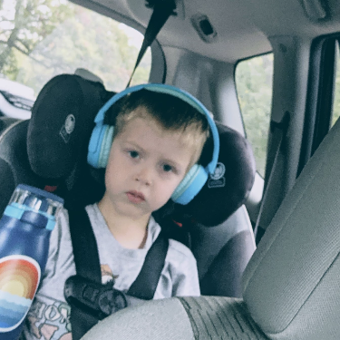 Child sitting in carseat with headphones