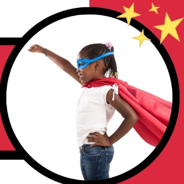 Young girl holding super hero pose and wearing red cape